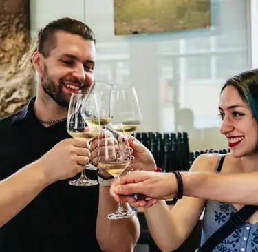 Travelers clinking glasses of white wine during a small-group winery tour in Austria.