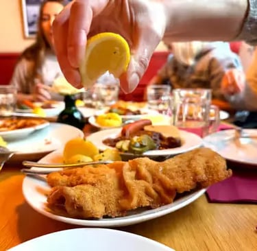 Squeezing fresh lemon over a crispy golden Wiener Schnitzel.