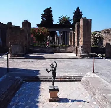 Bronze dancing faun statue in the courtyard of the House of the Faun, Pompeii ruins