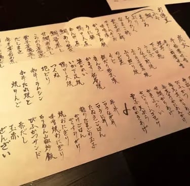 Handwritten Japanese kaiseki menu on paper at a traditional hidden restaurant in Kyoto