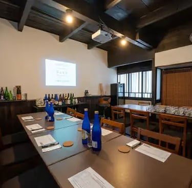 Traditional sake tasting room setup with bottles and projector in Fushimi Kyoto
