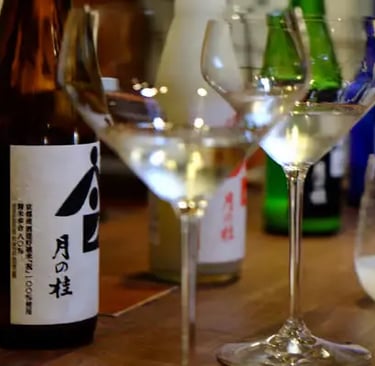 Japanese sake bottle with kanji label next to tasting glasses at Kyoto brewery