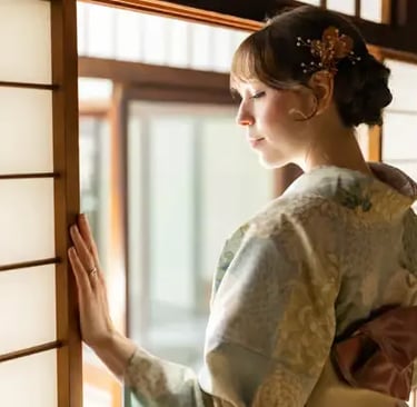 Woman in soft blue kimono with golden hair pin gazing through traditional shoji screen
