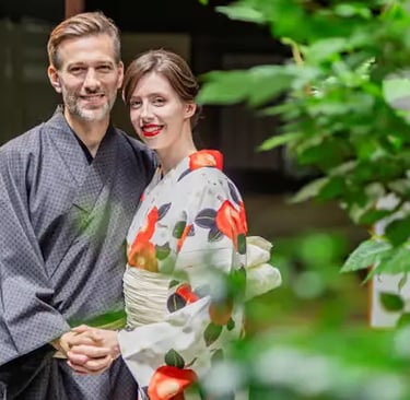 Happy couple in matching kimono smiling together in lush green Japanese garden Kyoto