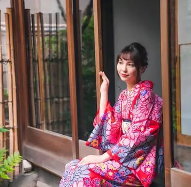 Woman in traditional floral kimono sitting in Japanese wooden doorway in Kyoto
