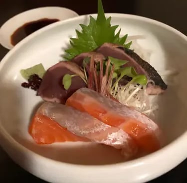 Fresh sashimi with salmon and tuna in white bowl with garnish