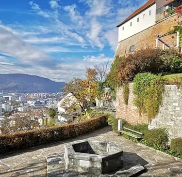 Panoramic view of Graz city from Schlossberg hill with ivy-covered stone walls