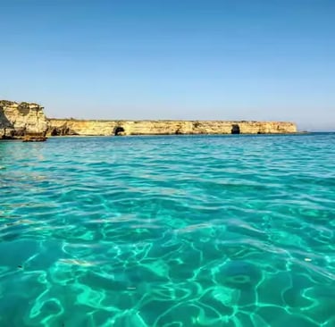 Crystal-clear turquoise Adriatic water and limestone cliffs of Salento coast near Torre dell'Orso