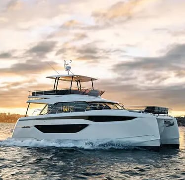 Prestige M48 power catamaran at golden hour with dramatic sunset sky on water