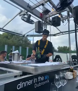Chef preparing beverages at Dinner in the Sky Dubrovnik platform kitchen with crane above