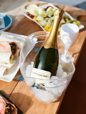 Chilled champagne bottle in ice bucket on luxury catamaran deck during private cruise in Milos
