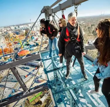 Tourists standing on the glass-bottom Platform 9 of the Vienna Giant Ferris Wheel.
