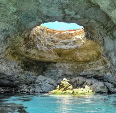 Interior of Otranto sea cave with natural skylight and turquoise water along Puglia coastline