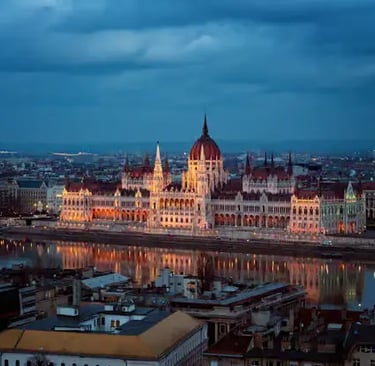 Hungarian Parliament Building illuminated at night reflecting on the Danube River in Budapest
