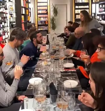 Guests seated at long table during Primitivo wine tasting event at Libreria Liberrima Bari