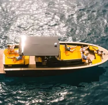 Aerial drone view of guests relaxing on a private boat in crystal-clear water