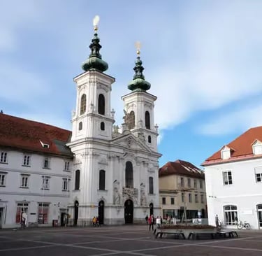 Beautiful white church architecture in the heart of Graz old town, showcasing the city's UNESCO World Heritage status.