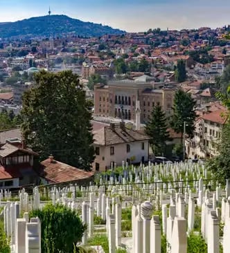 Sarajevo panoramic view with Vijećnica city hall, hillside cemetery, and surrounding mountains