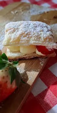 Sporcamuss pastry with cream filling and fresh strawberry on wooden board with checkered cloth