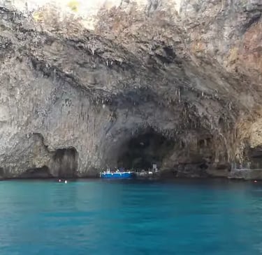Blue boat anchored at the entrance of Grotta Zinzulusa cave in Castro Puglia