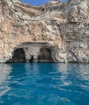 Blue Cave entrance on Biševo Island with limestone cliffs and bright blue Adriatic Sea