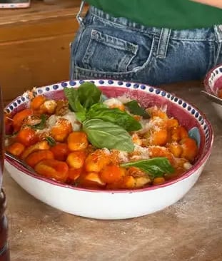 Fresh handmade gnocchi in tomato sauce with basil served in traditional ceramic bowl
