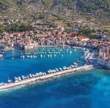 Aerial drone view of Komiža fishing village and turquoise harbor on Vis Island Croatia