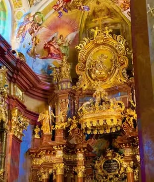 Ornate golden altar and colorful Baroque ceiling frescoes inside Melk Abbey church