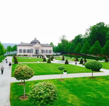 Manicured gardens and classical pavilion at Melk Abbey with sculpted trees and pathways