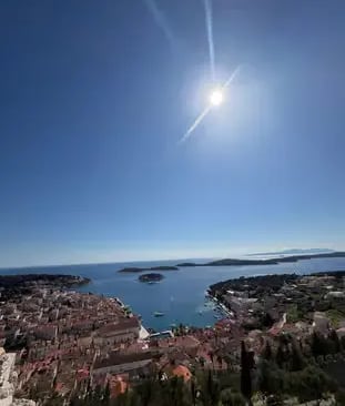 Sunlit panoramic view of Hvar town harbor and Pakleni Islands from fortress hilltop