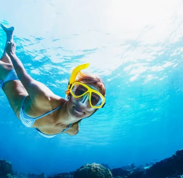 Woman snorkeling underwater in crystal clear blue water near Positano Amalfi Coast