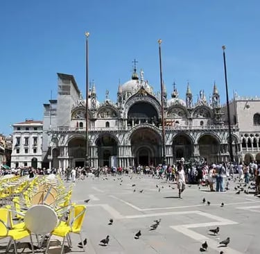 Tourists and pigeons at St. Mark's Square in front of the historic St. Mark's Basilica.