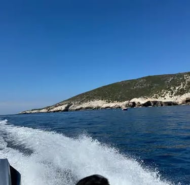 View from speedboat racing across Adriatic Sea toward Croatian island cliffs on sunny day