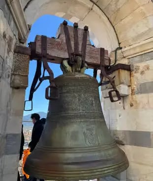 Large historic bell inside Pisa tower, seen during a Florence to Pisa day trip by train