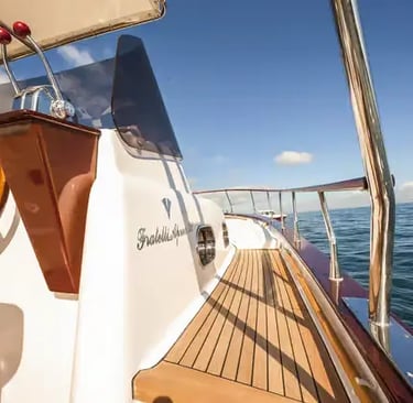 Wooden steering wheel and teak deck of a traditional Gozzo boat on the Amalfi Coast