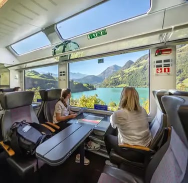Swiss Travel Pass train journey: Interior of a panoramic train carriage looking out over a lake and