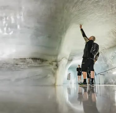 Tourists gathered near Swiss flags on the Sphinx Observation Terrace at Jungfraujoch Top of Europe.