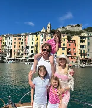 Family enjoying a private boat tour in Portovenere with colorful village backdrop