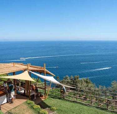 Outdoor dining terrace at Luna d'Agerola overlooking Gulf of Salerno with boats below