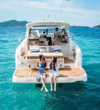 Two women relaxing on a private yacht swim platform in the Adriatic