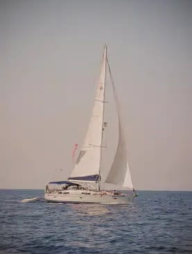Sailboat under full sail gliding through still waters of the Sulcis Archipelago