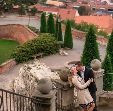  Couple kissing on Mikulov Castle stairs with panoramic red rooftop town view behind them