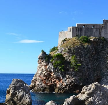 Fort Lovrijenac rising above rocky Adriatic coastline under clear blue sky Dubrovnik
