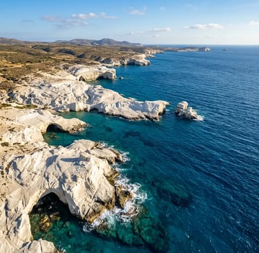 Aerial view of Milos white rock coastline and turquoise Aegean waters from helicopter