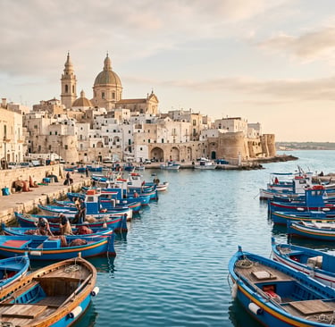 Traditional blue fishing boats in Monopoli harbor with white old town and cathedral, Puglia.
