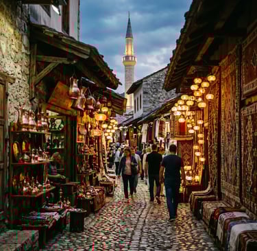  Mostar Old Bazaar cobblestone street with copper shops, Turkish lamps and minaret at dusk