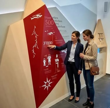 Tourists visiting the interactive exhibition at the Gornergrat summit, pointing at the 3000m altitud
