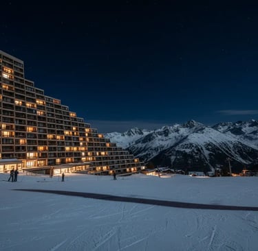 La Plagne resort at night showcasing illuminated alpine buildings against a snowy mountain backdrop