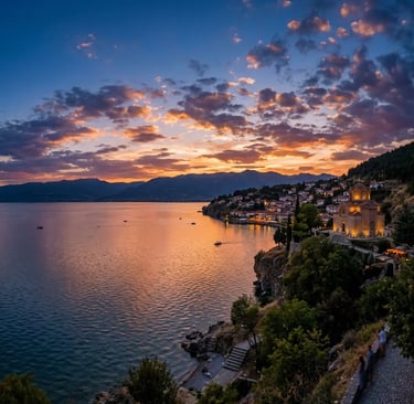 Panoramic sunset over Lake Ohrid with illuminated medieval church on rocky cliff