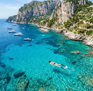 Person snorkeling in crystal clear turquoise water near Capri limestone cliffs aerial view